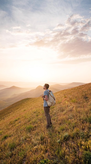 若い男が山を背景に一人旅する