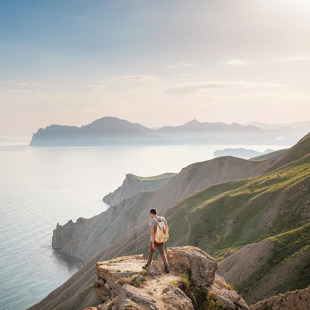 若い男が山を背景に一人旅する