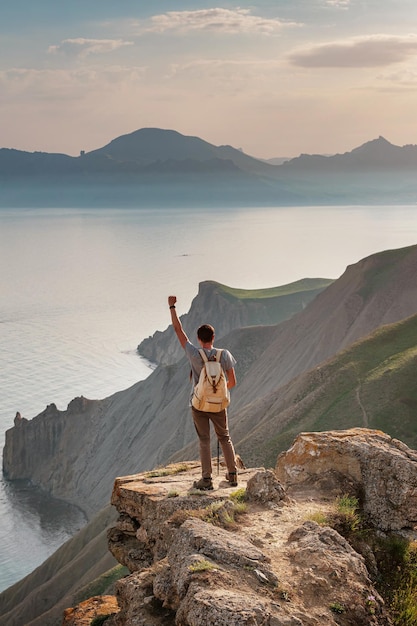 若い男が山を背景に一人旅する