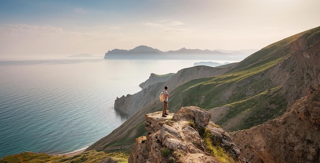 若い男が山を背景に一人旅する