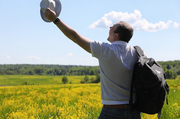 Young man travels with a backpack on a summer day outdoors