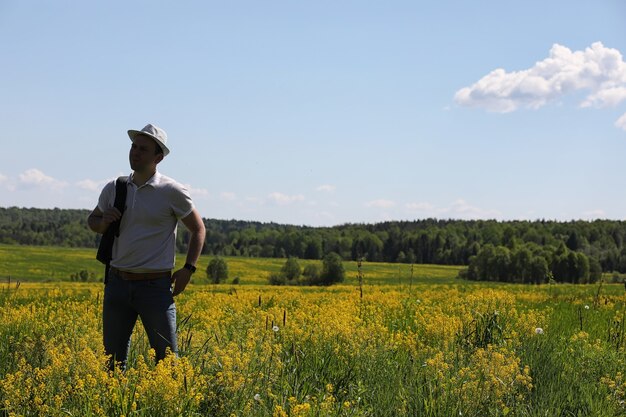 Young man travels with a backpack on a summer day outdoors