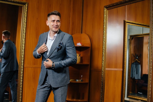 A young man tries on a new suit in the store's fitting room.