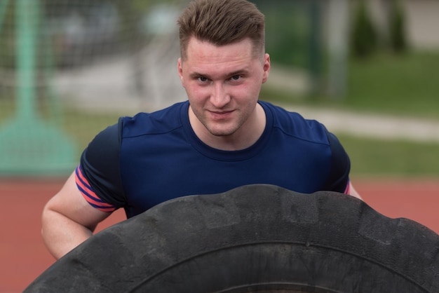 Young Man Turning Tire Over - Bodybuilding Exercises Truck Tire