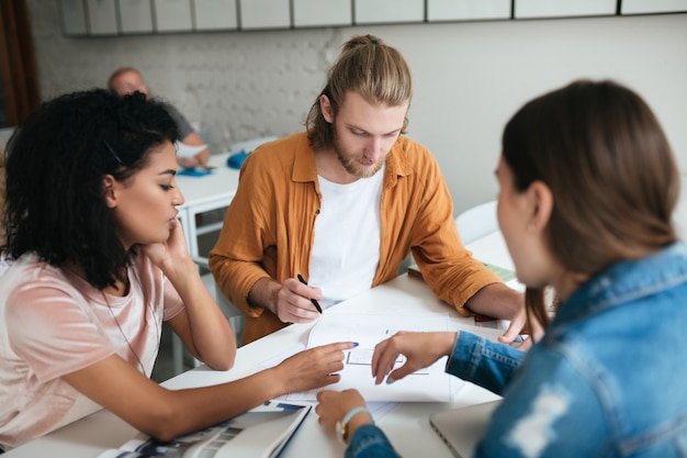 Young man and two womans working together in office