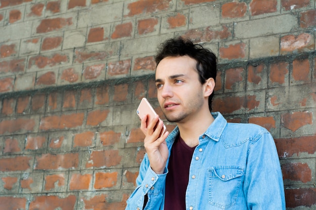 Young man typing on his phone.