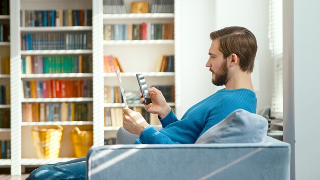 Young man typing on smartphone at home office