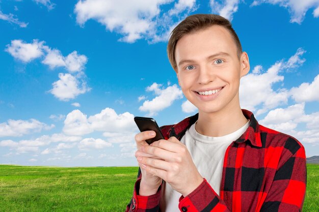 Young man typing text message on his cellphone