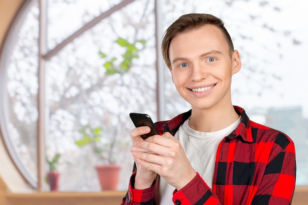 Young man typing text message on his cellphone