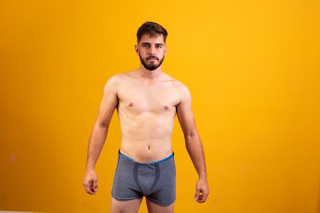 Photo young man in underwear facing camera