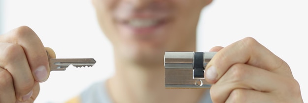 Young man in uniform holding keyhole and key closeup