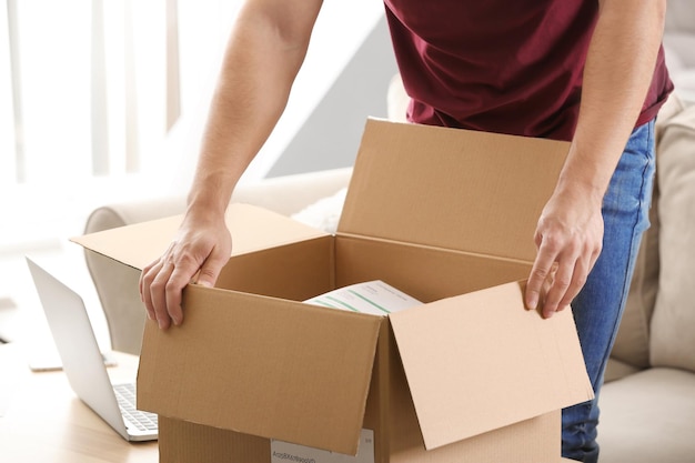 Young man unpacking parcel at home