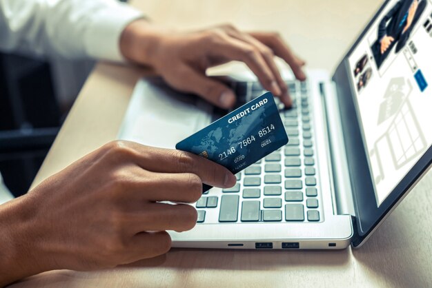 Il giovane usa la carta di credito per lo shopping online