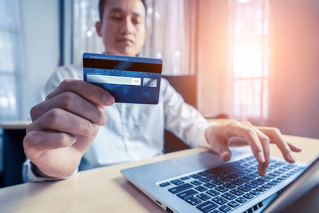 Young man use credit card for shopping payment online on laptop computer application or website