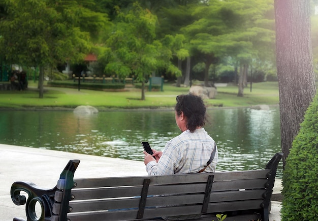 若い男が公園でスマートフォンを使う