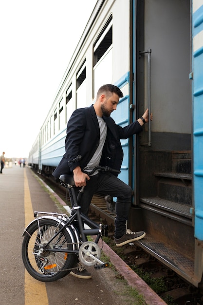 사진 기차로 여행하는 동안 접이식 자전거를 사용하는 청년