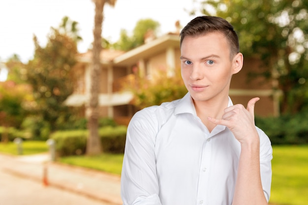 Young man using a call me gesture