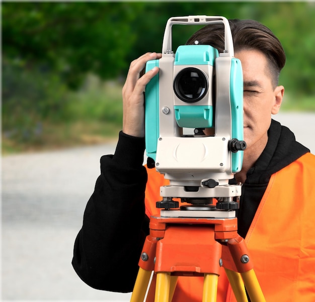 Giovane che per mezzo della macchina fotografica all'aperto