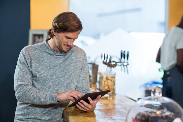 Photo young man using digital tablet at counter