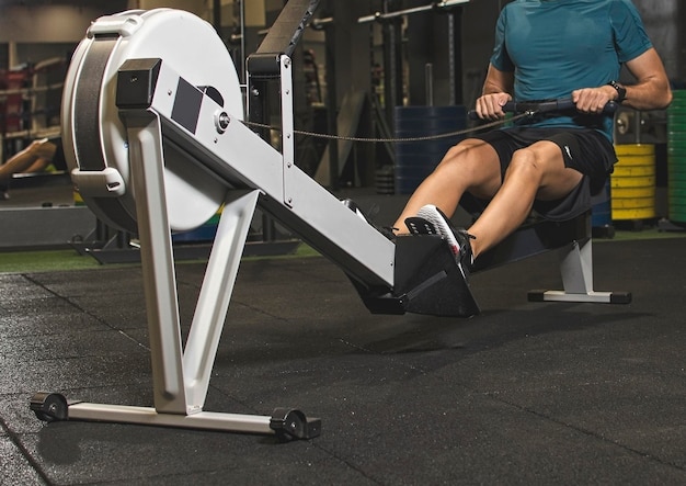 A young man using a fitness machine for exercise, sport gear