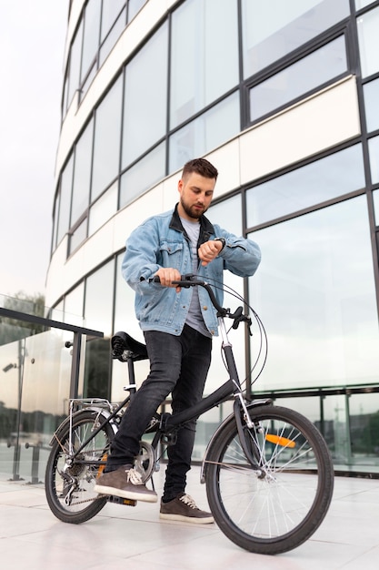 Photo young man using a folding bike in the city