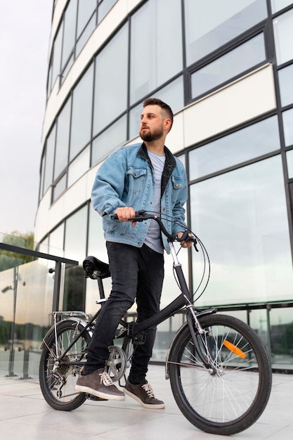 市内で折りたたみ自転車を使用している若い男