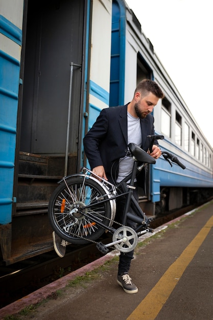 Young man using a folding bike while traveling by train