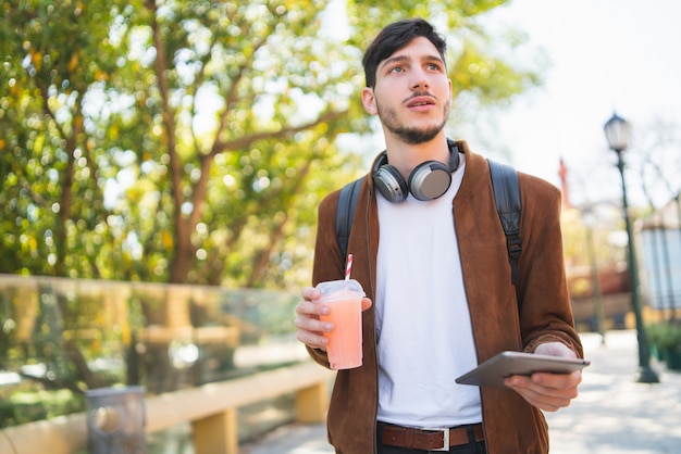 若い男が彼のデジタルタブレットを使用しています。