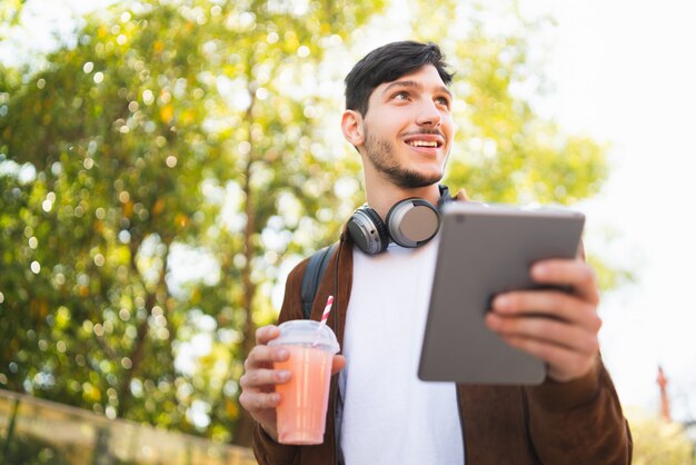 Giovane che per mezzo della sua compressa digitale.