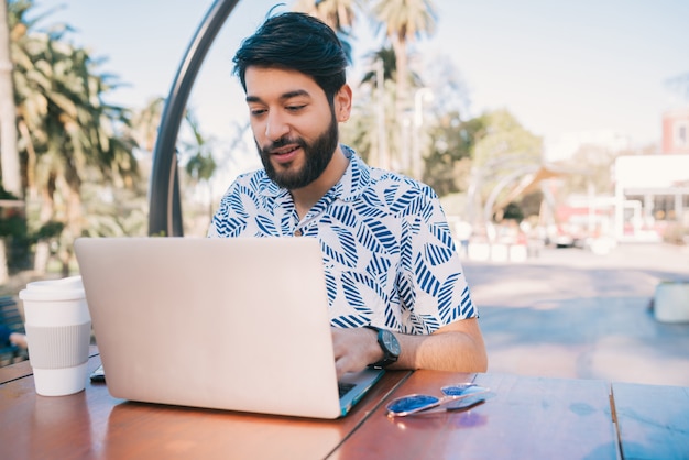 Young man using his laptop in a coffee shop.