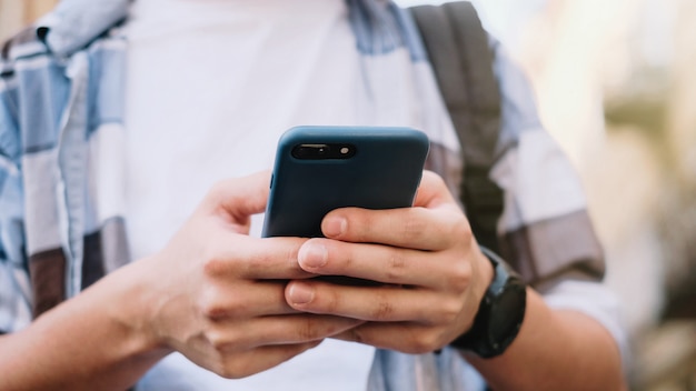 Young man using his mobile phone in city. Close up of a man using mobile smart phone