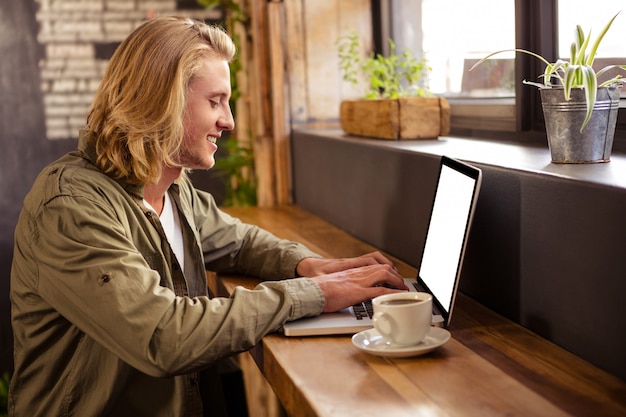 Giovane che utilizza computer portatile nel self-service