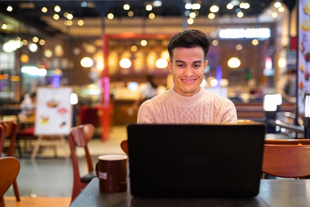 Young man using laptop computer at coffee shop