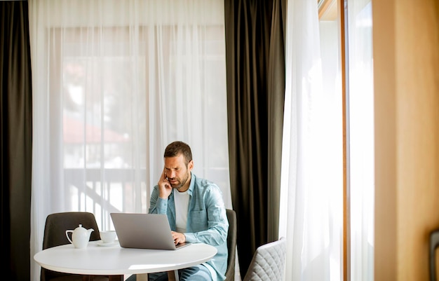 Young man using laptop and drink tea in the living room