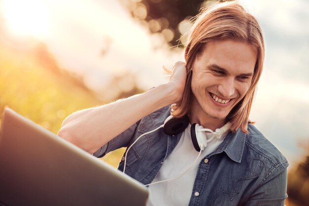 Young man using laptop outdoors