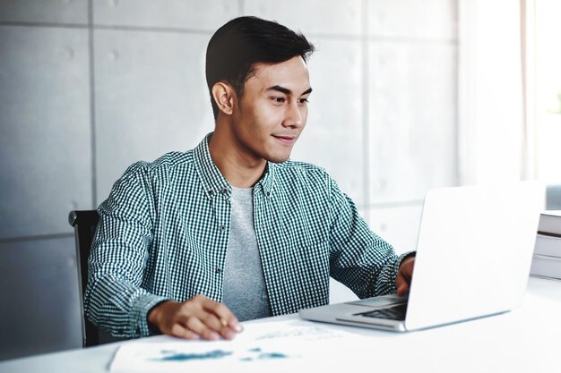 Young man using laptop while sitting at table