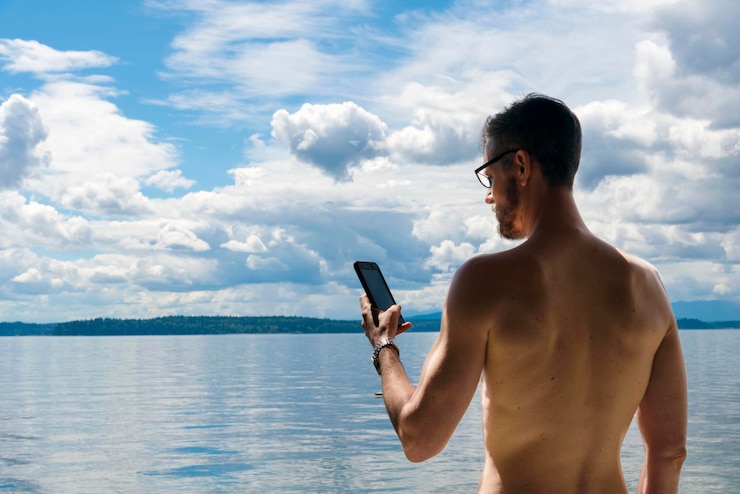 Photo young man using mobile phone in vacations