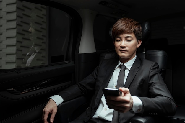 Photo young man using mobile phone while sitting in bus