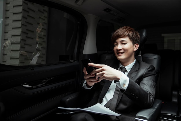 Photo young man using mobile phone while sitting in bus