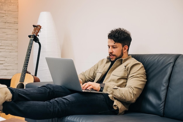 Young man using mobile phone while sitting on sofa