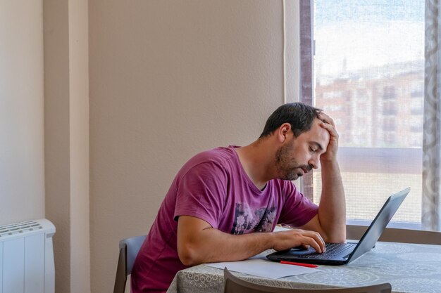 Photo young man using mobile phone while sitting on table