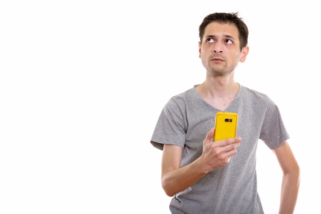 young man using mobile phone while thinking