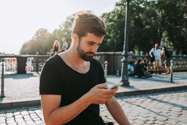 Photo young man using mobile phone