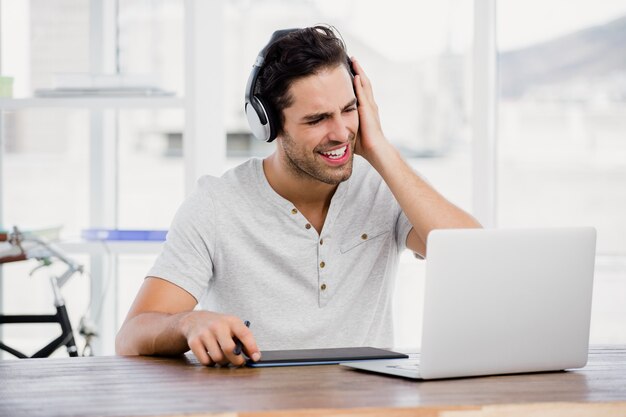 Young man using pen tablet and laptop