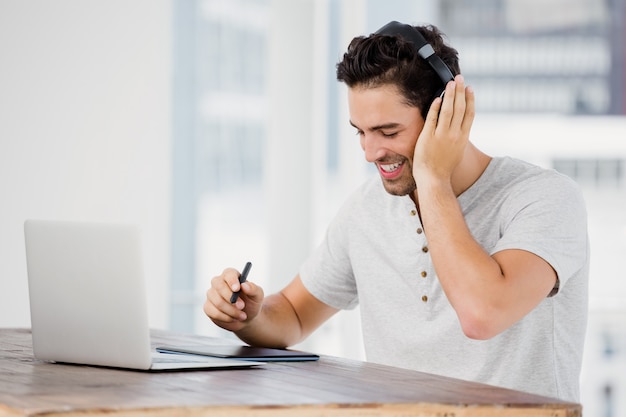 Young man using pen tablet and laptop