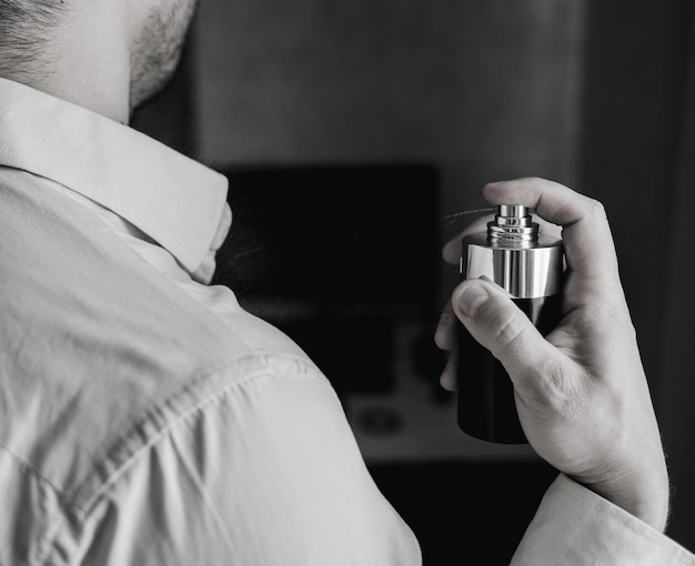 Young man using perfume