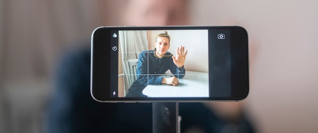 Young man using a phone and chatting on a video call online