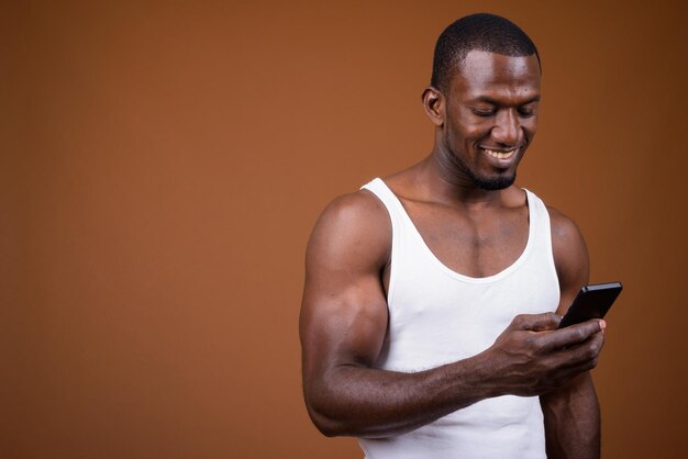 Photo young man using smart phone against gray background