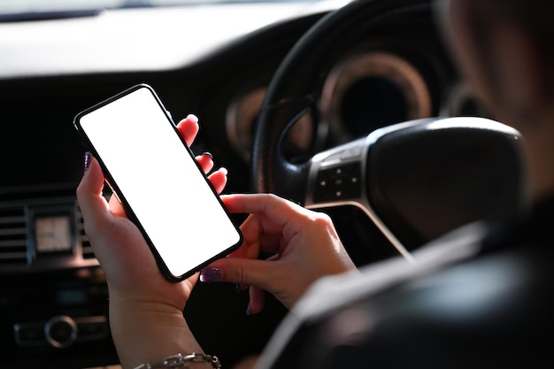 Young man using smart phone mobile phone in car Close up view