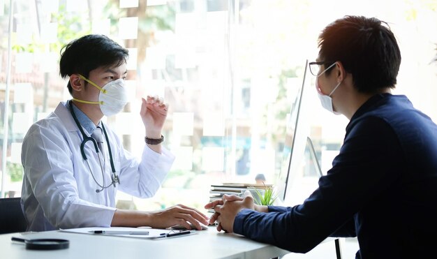 写真 テーブルの上でスマートフォンを使っている若い男